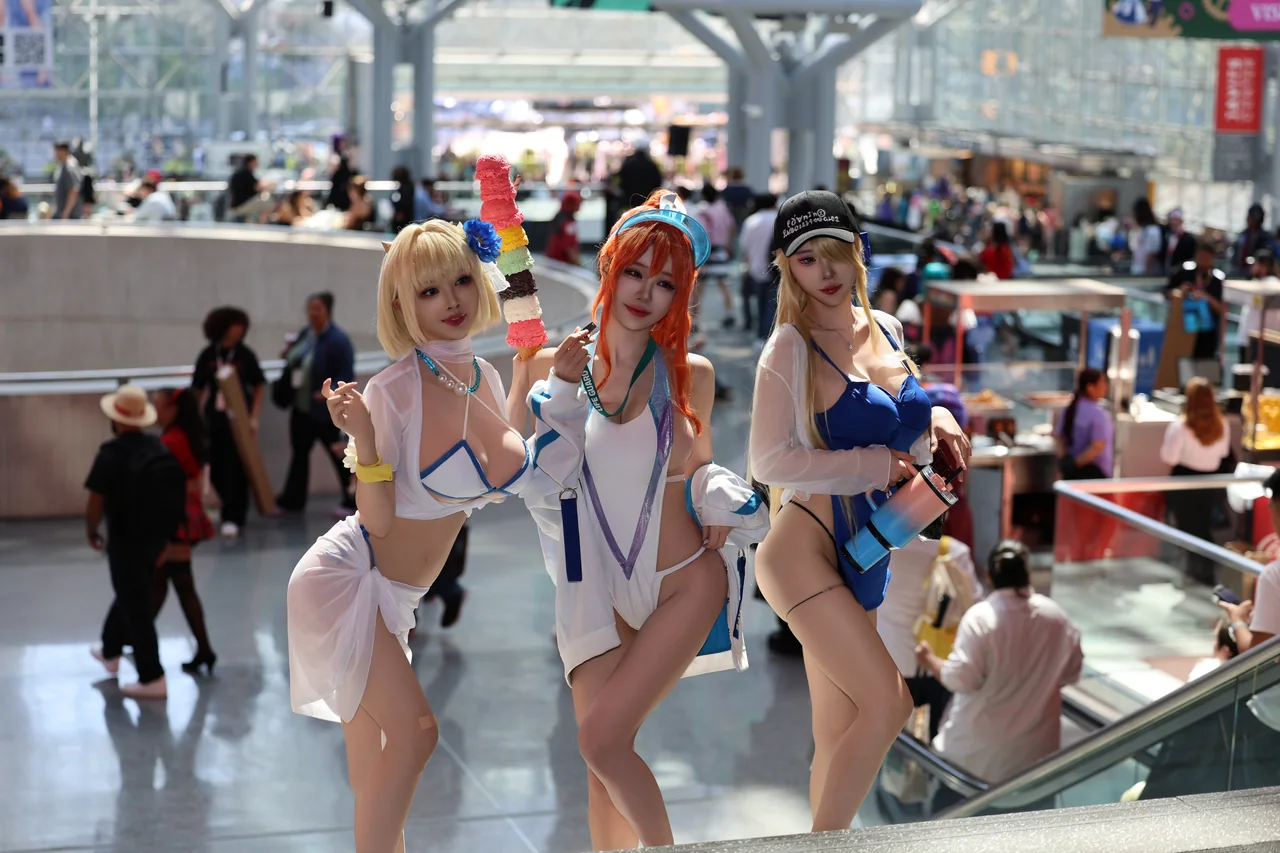 Three cosplayers posing in a sunlit convention hall