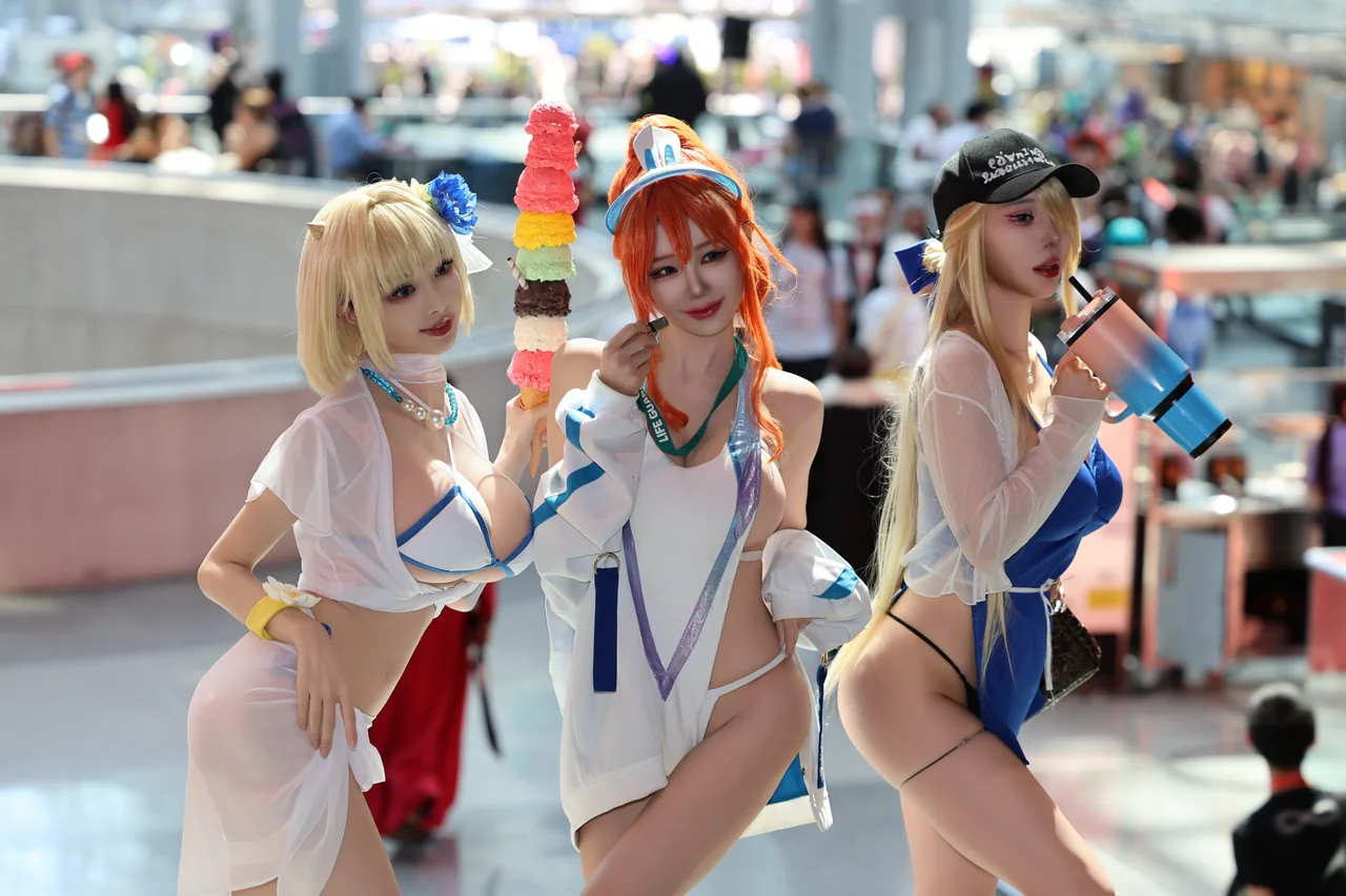 Three cosplayers in blue and white costumes posing together