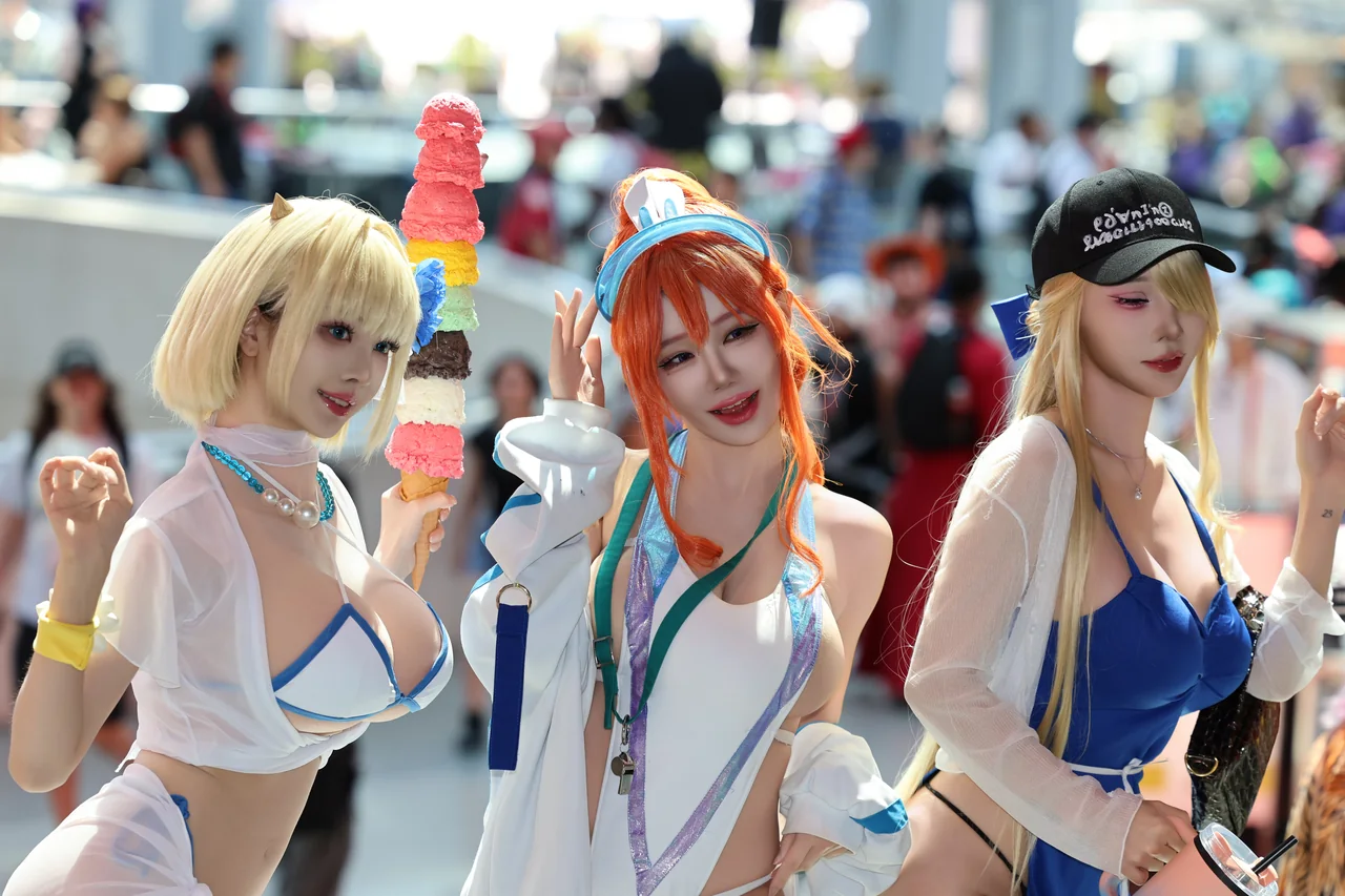 Close group portrait of three cosplayers in a bright convention hall