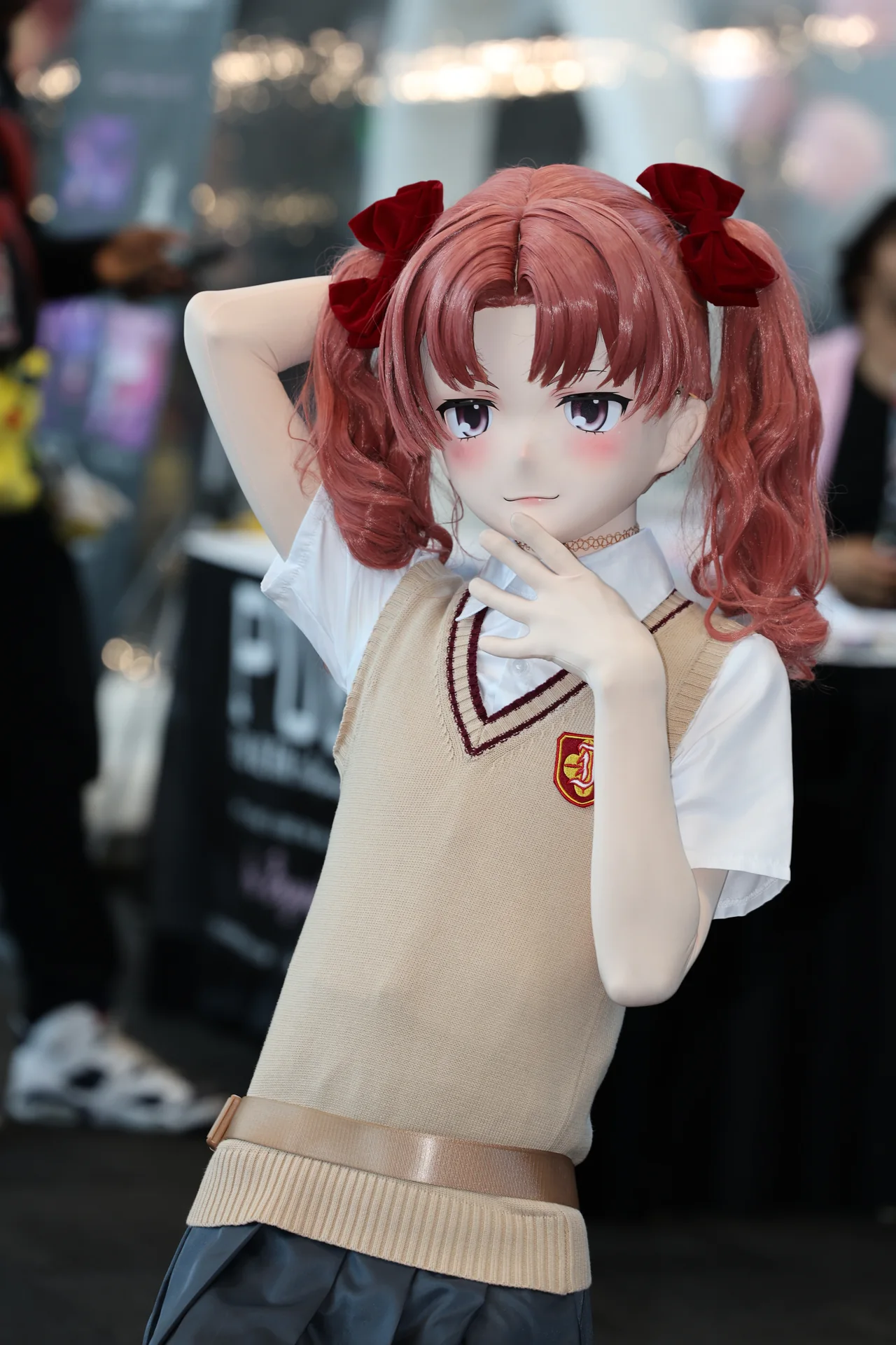 A cosplayer wearing a red-haired character mask and a school uniform